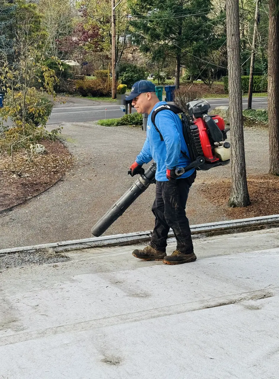 Crew member in a company shirt carrying a backpack blower