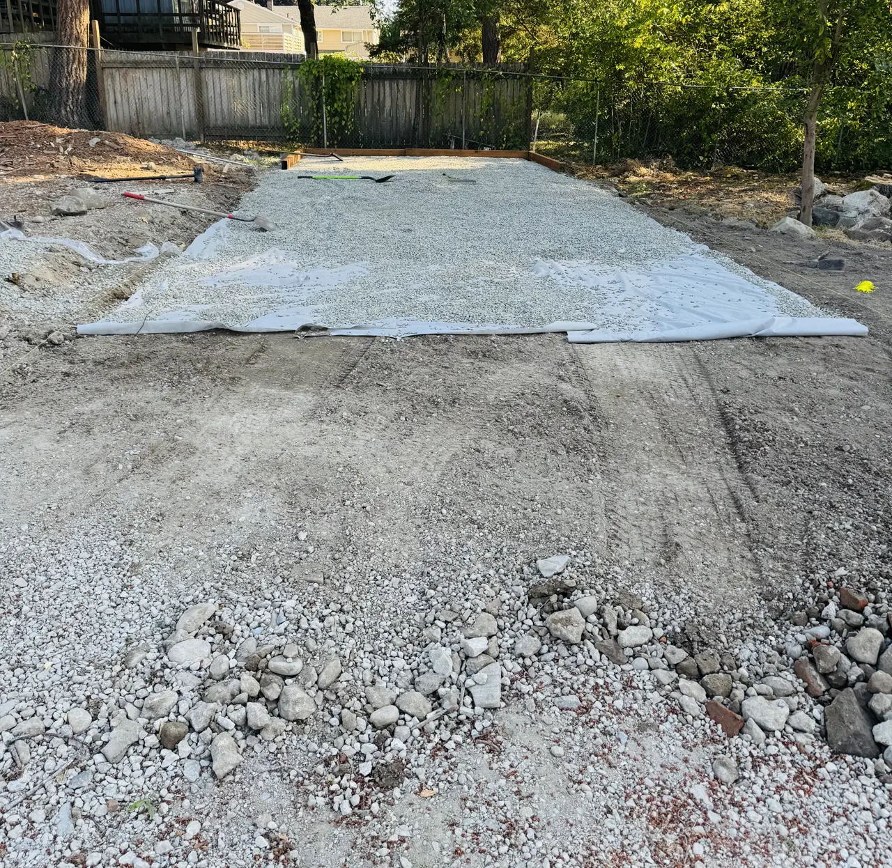 Gravel base and landscape fabric laid out for a rectangular yard area