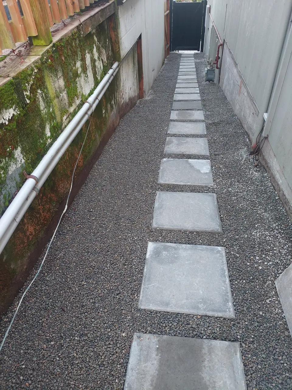 Concrete stepping stones set into the gravel path in the same side yard